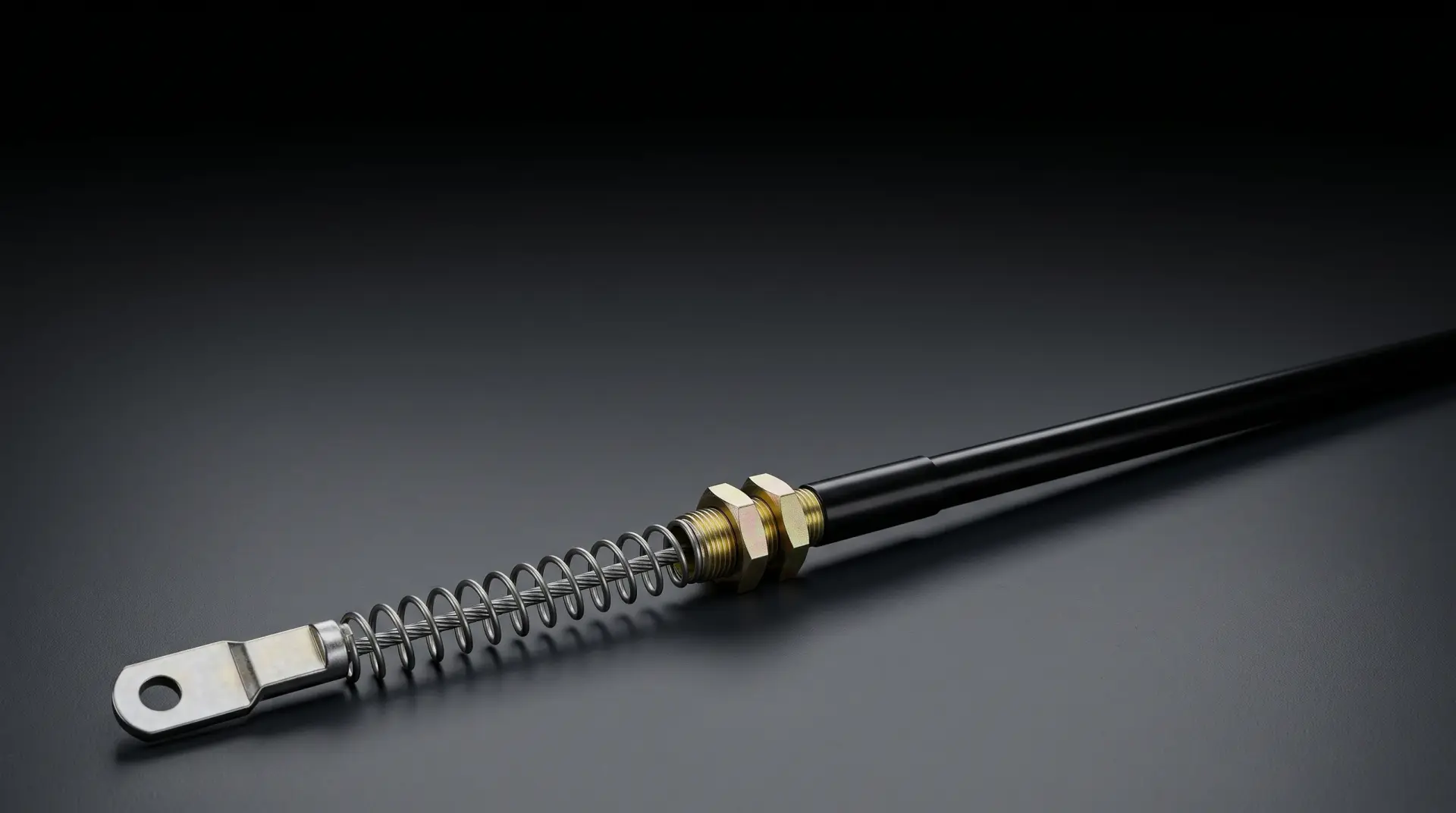 Ilustración de un cable mecánico industrial con fijación roscada de dos tuercas, resorte y terminal de ojo.