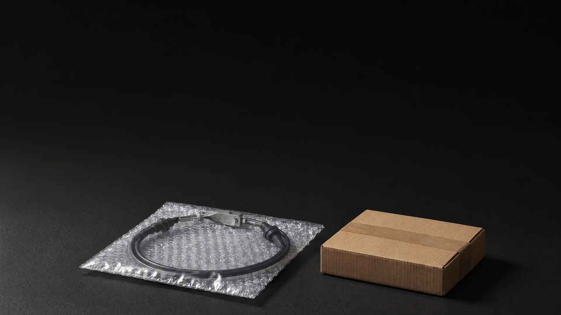 Ilustración de un chicote de clutch sellado en bolsa de plástico burbuja junto a una caja de cartón cerrada.